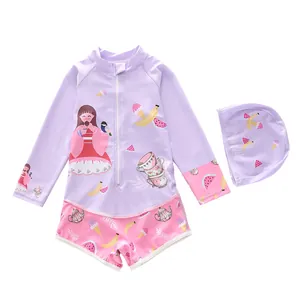 Detailed view of long sleeve kids swimsuit with cartoon patterns and matching swim cap