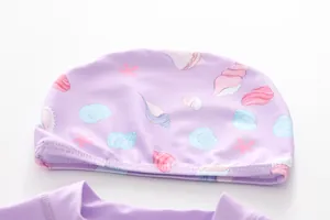 Detailed view of lavender swimming cap featuring ocean shell prints and elastic fabric