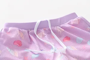 Close-up of purple mesh swim shorts with sea shells pattern and white drawstring