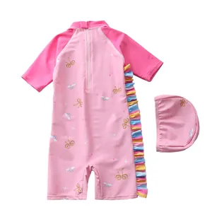 Détail d'un maillot de bain rose pour filles avec motifs arc-en-ciel et volants colorés