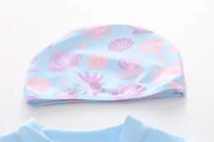 Close-up of light blue kids swim cap with pink sea shell and starfish patterns