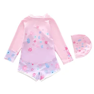 Detailed view of girls' long-sleeve pink floral swimsuit and matching swim cap