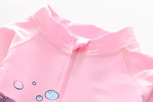 Detailed close-up of girls' pink swimwear featuring a zipper guard and bubble print