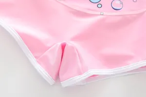 Detailed view of pink swim shorts with bubble print and white contrast hem stitching