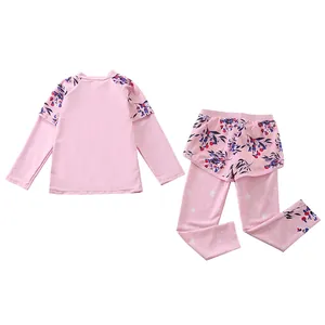Detailed view of pink long-sleeved kids swimwear with floral print and white star patterns