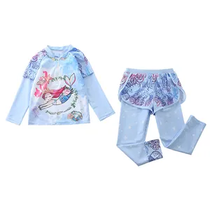 Detail of girls' long-sleeve swimwear featuring mermaid and sea creature prints on blue fabric
