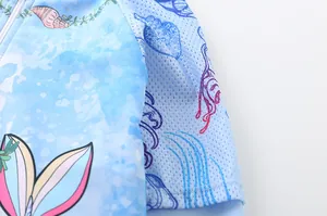 Detail of child swimsuit featuring ocean patterns and breathable mesh sleeve textures