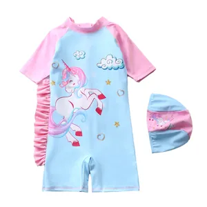 Maillot de bain licorne à volants roses avec bonnet de bain assorti sur fond blanc