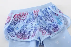 Detail of light blue girls' swim shorts with mesh outer layer and jellyfish print