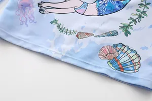 Detailed macro view of the mermaid and jellyfish print on the blue fabric of the swimsuit