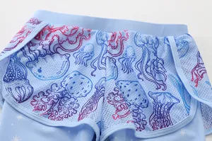Detail of girls' light blue swimwear shorts featuring double-layered jellyfish mesh fabric