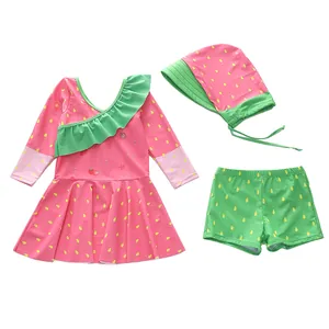 Dettaglio del set da nuoto per bambina a tema fragola con maglia, pantaloncini e cuffia
