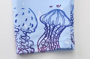 Detail of double-needle stitching on light blue kids swimsuit with jellyfish print