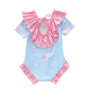 Détail d'un maillot de bain fille avec imprimés marins, volants roses et dos nu