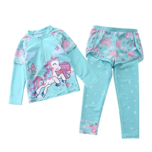Detail of girls two-piece swimsuit with long sleeves and unicorn castle print
