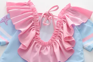 Détail des volants roses et imprimé étoile de mer sur le dos du maillot de bain fille