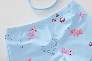 Dettaglio dei pantaloncini da nuoto per bambina azzurri con motivi marini ed elastico