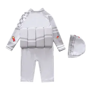 Detail van grijs kinderzwempak met lange mouwen, drijfblokken en sterrenprint met zwemmuts