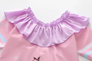 Détail du col de maillot de bain rose pour fille avec volants et motifs étoilés