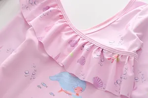 Dettaglio costume da bagno rosa bimba con ruches e stampe di sirene e conchiglie