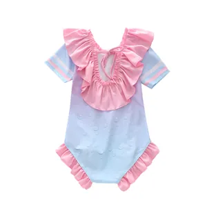 Détail de l'encolure à volants roses et laçage au dos du maillot de bain bleu dégradé