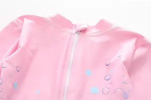 Détail de maillot de bain fille rose avec fermeture éclair blanche et col montant