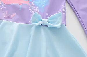 Vue détaillée du maillot de bain sirène enfant montrant le tissu violet et le nœud bleu