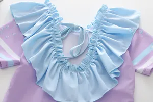 Détail du maillot de bain fille avec volants, dos lacé et motifs de bulles bleues