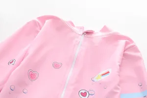 Détail d'un maillot de bain rose à manches longues pour filles avec fermeture éclair blanche