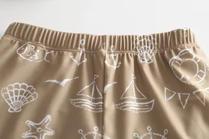 Detail der khakifarbenen Badehose mit weißen nautischen Motiven und Dehnbund