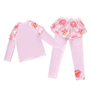 Detail of girls' long sleeve pink swimsuit set with sweet donut and cupcake prints