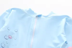 Détail du rashguard pour bébé fille avec protège-zip et imprimé de coquillages