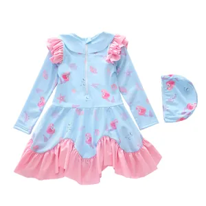 Detail view of light blue mermaid print swimsuit with pink ruffles and matching swim cap