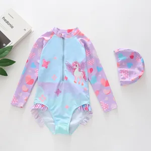 Detail of girls' long sleeve swimsuit with unicorn print, frilled hem and matching swim cap