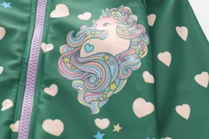 Close-up of unicorn print with rainbow hair and heart details on green kids swimwear