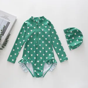 Detail of girls long sleeve green one-piece swimsuit with white heart pattern and ruffles