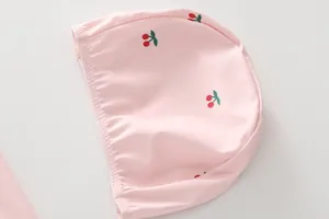 Detail of pink girls swim cap with cherry print made of quick-dry elastic fabric