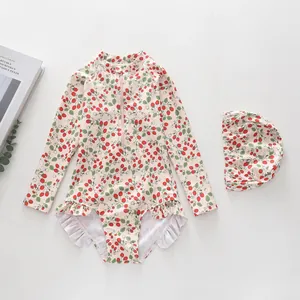 Flat lay of girl's long sleeve swimsuit with strawberry print and ruffle details