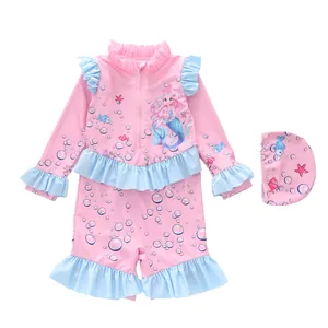 Flat lay of pink long-sleeved girls' swimsuit with mermaid prints and blue ruffle details