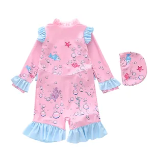 Detailed view of pink long-sleeved girls swimsuit with ruffles and sea patterns