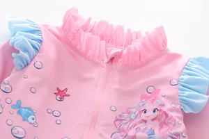 Detail of pink girls swimsuit featuring ruffled collar and cute mermaid ocean print