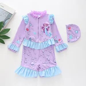 Flat lay of lilac girl's long sleeve swimsuit with ruffles and mermaid pattern with cap