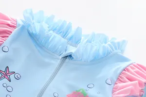 Detail of blue girls' swimsuit featuring pink ruffle collar and starfish print