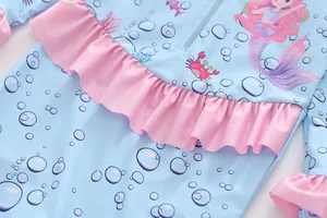 Detail of girls' mermaid swimsuit featuring ruffle trim and ocean creature prints