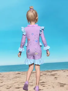 Girls long sleeve one-piece swimsuit with ocean prints and ruffle trim at the beach