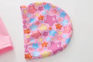 Detail van roze kinderbadpak met kleurrijke sterpatronen en hoogwaardige stiksels