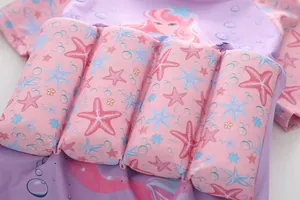 Detail of girls buoyancy swimsuit featuring pink starfish prints on purple floatation blocks