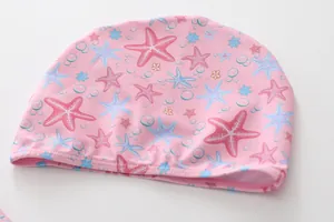 Close-up of pink girls' swim cap with colorful starfish patterns and reinforced stitching