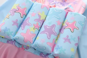 Detailopname van de drijvende vulling en zeesterren op het roze en blauwe kinderbadpak