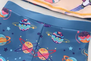 Close-up of boys' swimwear fabric with colorful space planets and rocket patterns